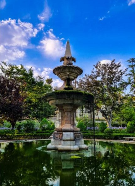 Fountain in the Botanical Garden of Coimbra under a blue sky